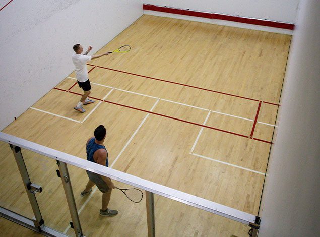 people playing racquetball in a modern gym
